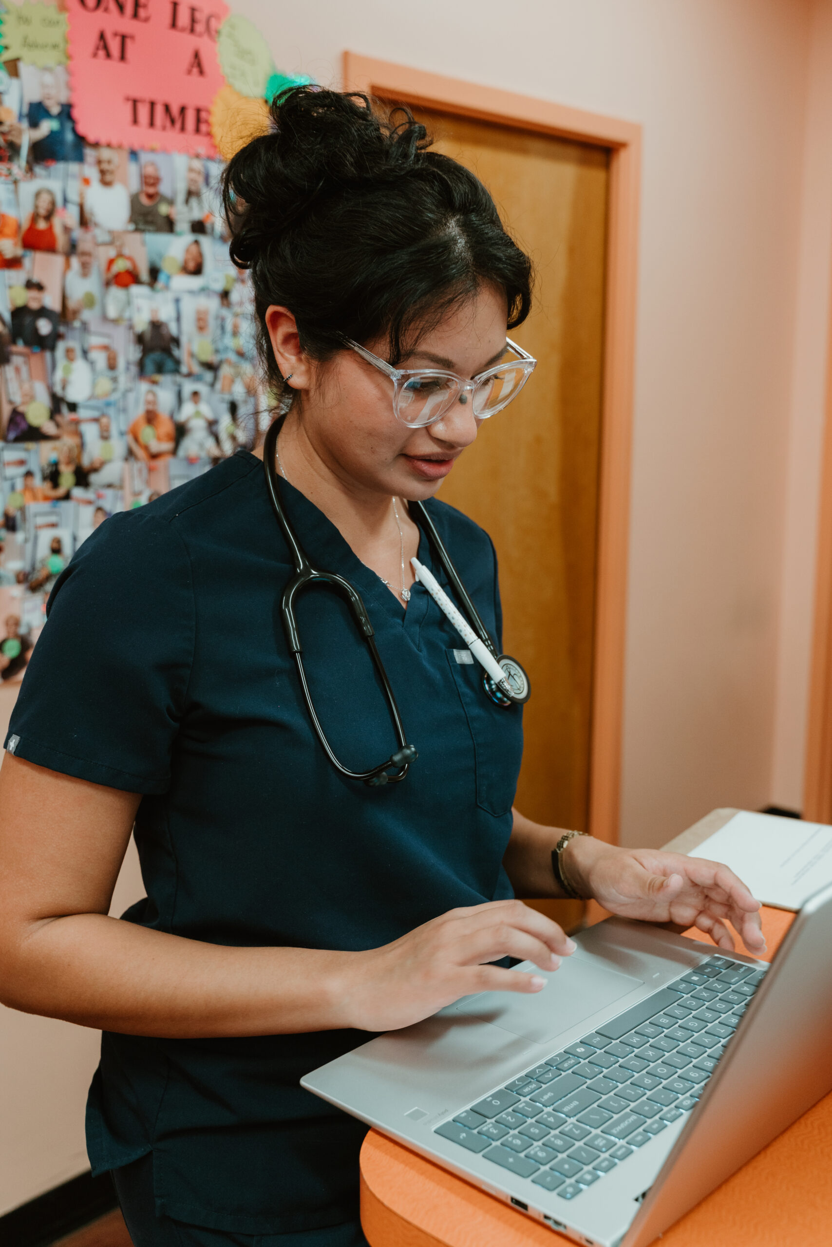 Medical assistant in dark blue scrubs working at a laptop at Island Doctors Palm Coast McCormick