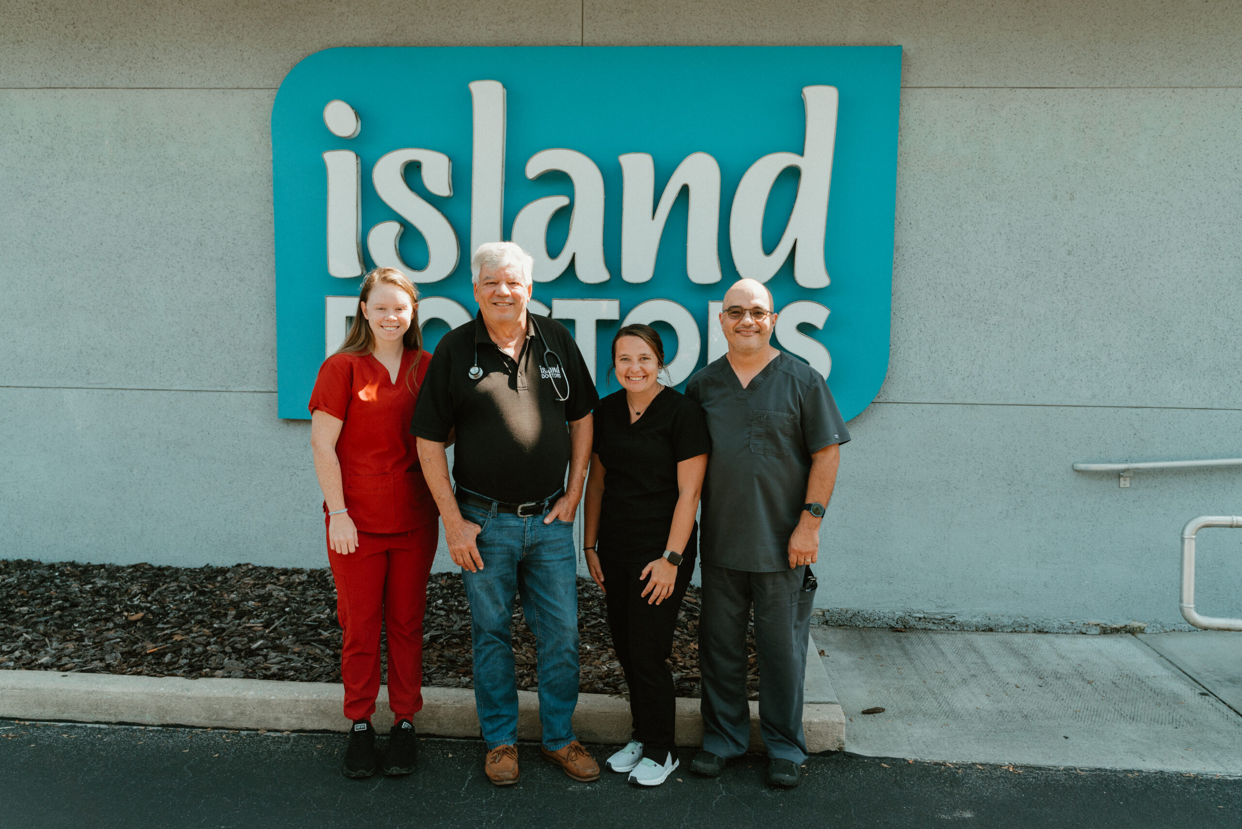 Island Doctors care team standing outside an office beneath the Island Doctors sign