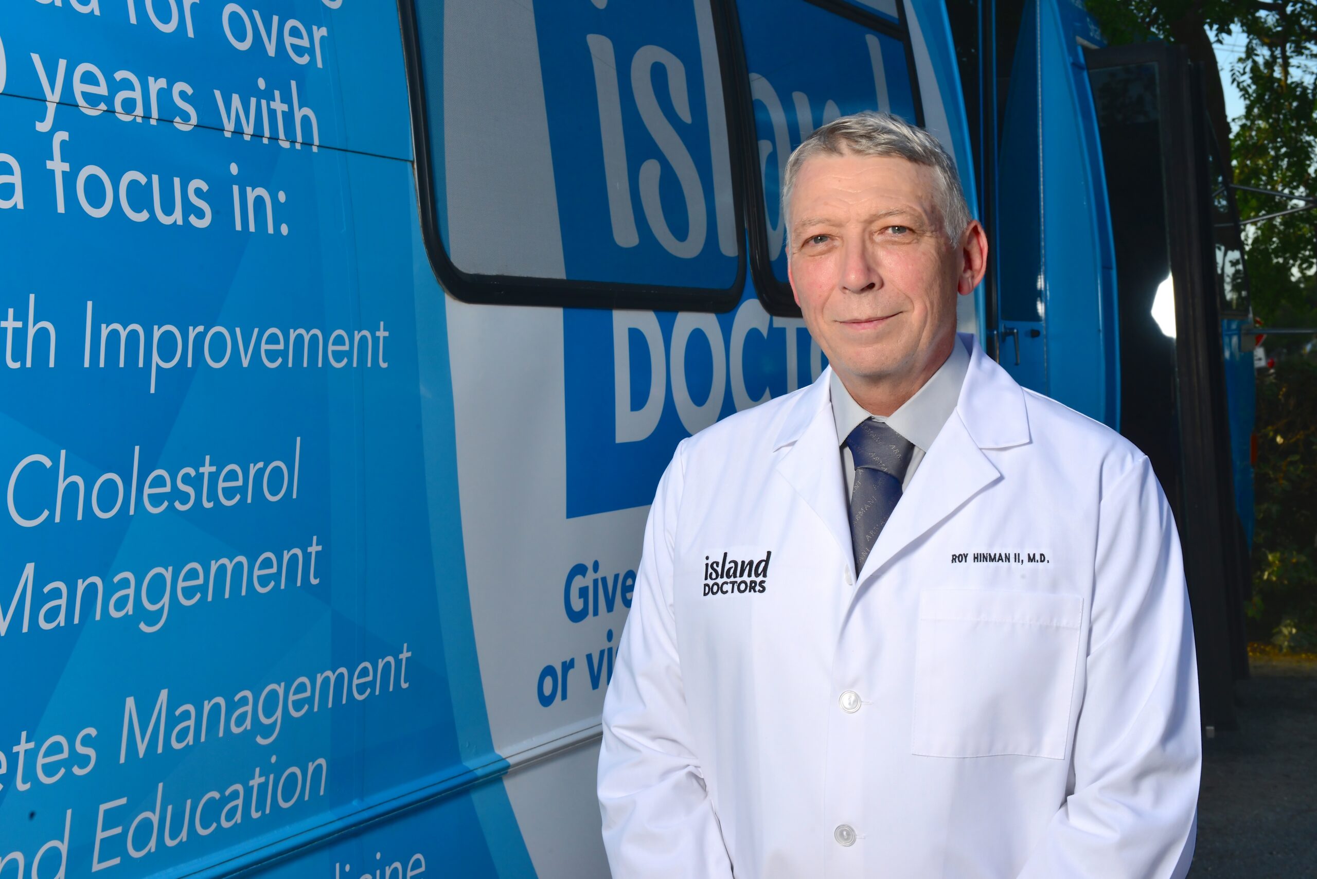 Island Doctors physician beside a blue Island Doctors vehicle